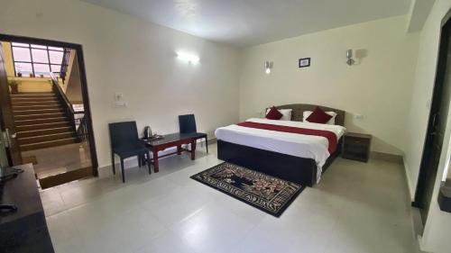 a bedroom with a bed and a desk and a staircase at Lingmoo Residency in Ravangla