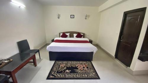 a bedroom with a bed and a table and a desk at Lingmoo Residency in Ravangla