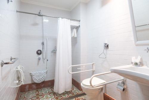 a white bathroom with a shower and a toilet at Hotel Boutique Balcón de la Plaza in Salta