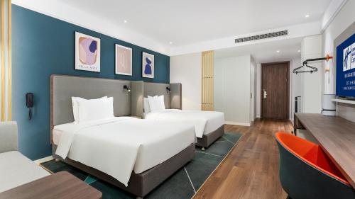 a hotel room with two beds and a television at Holiday Inn Express Xining Railway Station by IHG in Xining