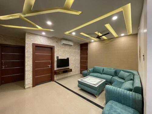 a living room with a couch and a tv at SunRays - Unique 3BHK in the Heart of the City in Gwalior