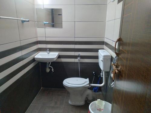 a bathroom with a toilet and a sink at Homely Home stay in Kalpetta