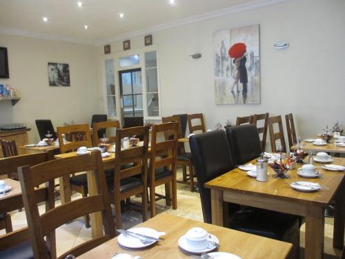 a dining room with wooden tables and chairs at Belvedere Hotel in London