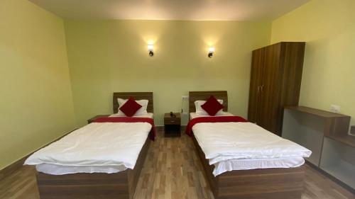 a room with two beds in a room at Lingmoo Residency in Ravangla