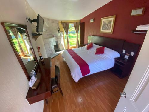 una camera con letto bianco e pareti rosse di Hotel Campestre Imperial a Huasca de Ocampo
