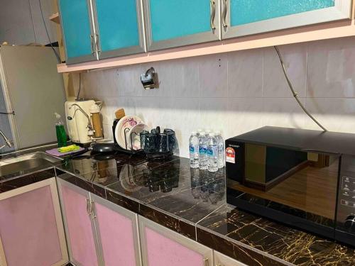 a kitchen with a counter top with a microwave at Homestay by Tas in Kulai