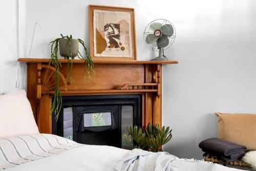 a living room with a fireplace with a television at Iconic Lygon street Home, Carlton in Melbourne