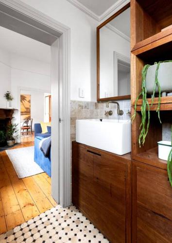 a bathroom with a sink and a mirror at Iconic Lygon street Home, Carlton in Melbourne