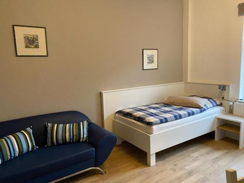 a small bedroom with a bed and a couch at Pension Grunwald in Sehnde