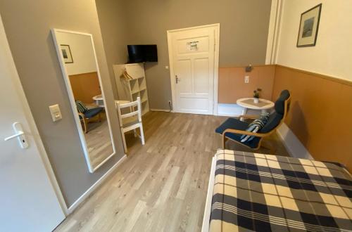 a small room with a bed and a table and chairs at Pension Grunwald in Sehnde