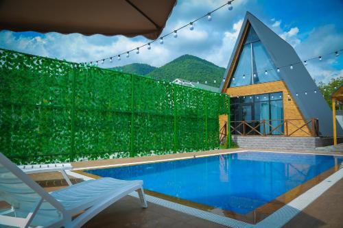 a villa with a swimming pool and a chair at Triangle Villa Gabala. in Gabala