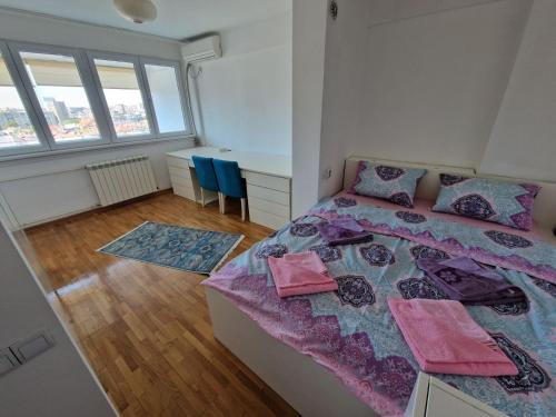 1 dormitorio con 1 cama, escritorio y ventanas en Harmony Apartment, en Belgrado