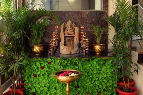 a green wall with a statue and plants on it at Grand Regency Rajajinagar, Iskcon Temple - WTC in Bangalore