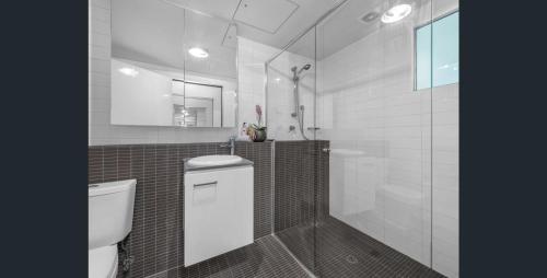 a bathroom with a white toilet and a shower at Story Apartments in Brisbane