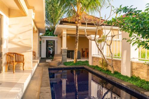 ein Haus mit einem Pool vor einem Haus in der Unterkunft Rice field view Villa, Pool & Kitchen, 2 bedroom in Ubud
