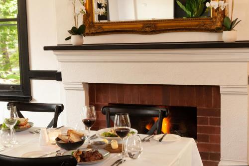 a table with a plate of food and a fireplace at Dormie House in Moss Vale