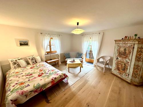 a bedroom with a bed and a living room at Auszeitshäusel ideal für Naturfreunde und Wanderer in Marktschellenberg