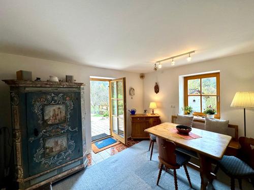a living room with a wooden table and a room with a door at Auszeitshäusel ideal für Naturfreunde und Wanderer in Marktschellenberg