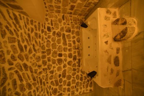 a bathroom with a wall covered in rocks at Legacy Mesopotamia Hotel in Mardin