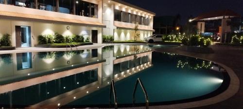 a swimming pool in front of a building at night at Mayur Belgaum Presidency Hotel & Spa in Belgaum