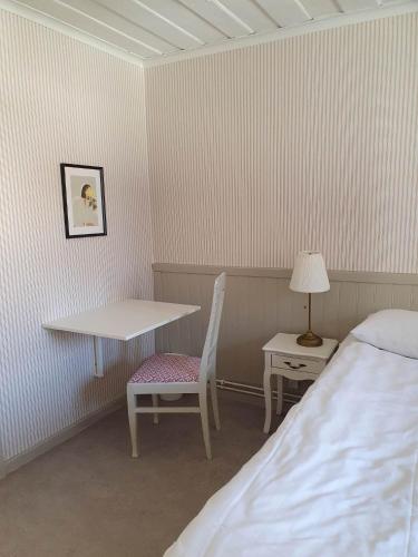 a room with a bed and a table and a chair at Epokgården in Öregrund