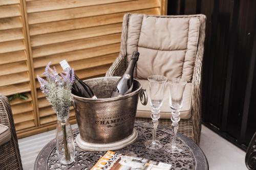 a bucket of wine sitting on a table with glasses at Matamata Country B&B in Matamata
