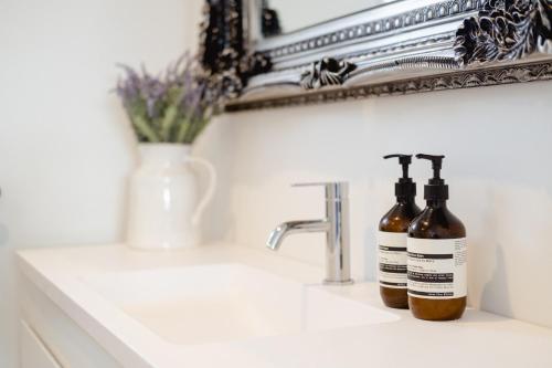 two bottles of soap sitting on a bathroom sink at Matamata Country Retreat in Matamata