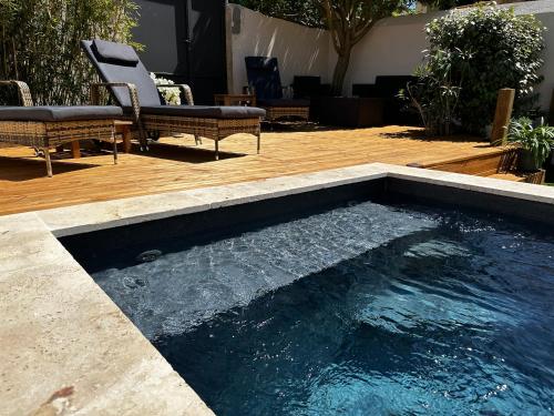 a swimming pool in a backyard with a wooden deck at Appart'hôtel 27 le lion d'or in Malaucène