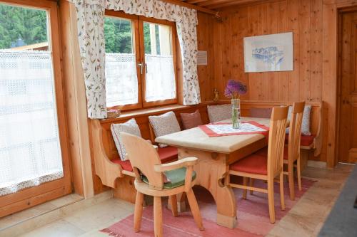a dining room with a wooden table and chairs at Alte Bildhauerei in Aurach bei Kitzbuhel