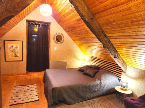 a bedroom with a bed and a wooden ceiling at La Combe aux oiseaux in Villefranche-de-Rouergue
