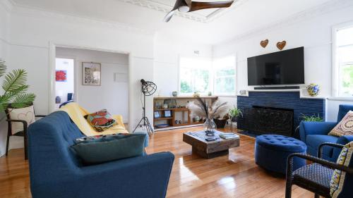a living room with blue furniture and a fireplace at Agapi Daylesford in Daylesford