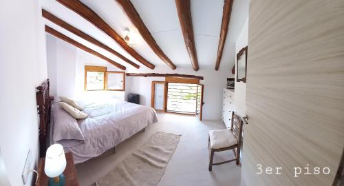 a bedroom with a bed and a chair in a room at Casa del Puente in Nerpio