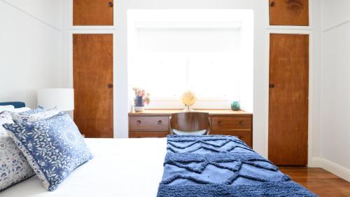 a bedroom with a bed with a blue blanket on it at Agapi Daylesford in Daylesford
