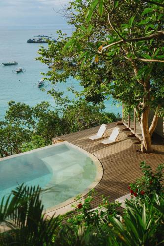 a swimming pool on a wooden deck next to the ocean at Morin Resort in Nusa Lembongan