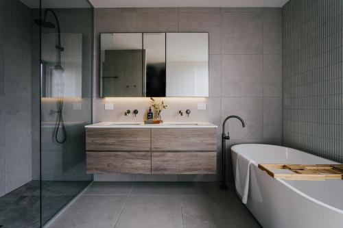 La salle de bains est pourvue d'un lavabo, d'une baignoire et d'un miroir. dans l'établissement Drummond Estate - Daylesford Macedon Region, à Drummond