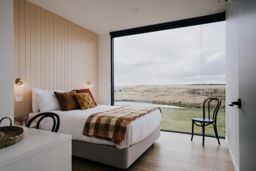 - une chambre avec un lit et une grande fenêtre dans l'établissement Drummond Estate - Daylesford Macedon Region, à Drummond