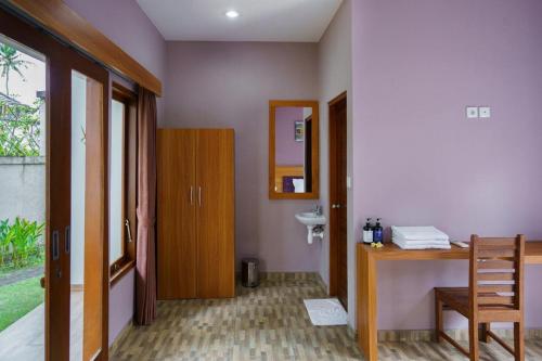 La salle de bains est pourvue d'un lavabo, d'un bureau et d'un miroir. dans l'établissement Ariana Beach Resort Amed Bali, à Amed