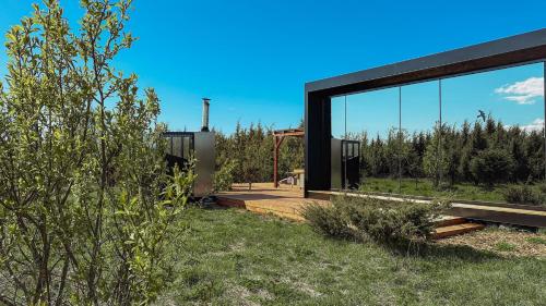 a modern house with a large glass window at Juniper Minivilla Jacuzzi & Sauna in Söderby