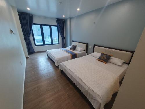 um quarto com 2 camas e uma grande janela em Rosa Quỳnh Anh em Haiphong