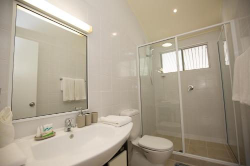 a bathroom with a toilet and a sink and a shower at Gateway Hotel in Port Moresby
