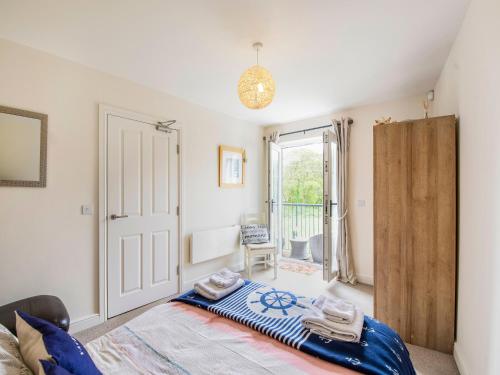 a bedroom with a bed and a door to a balcony at Harbour Retreat in Garlieston