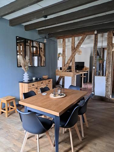 a dining room with a wooden table and chairs at Bienvenue chez vous 