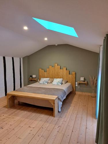 a bedroom with a large bed with a wooden headboard at Bienvenue chez vous 