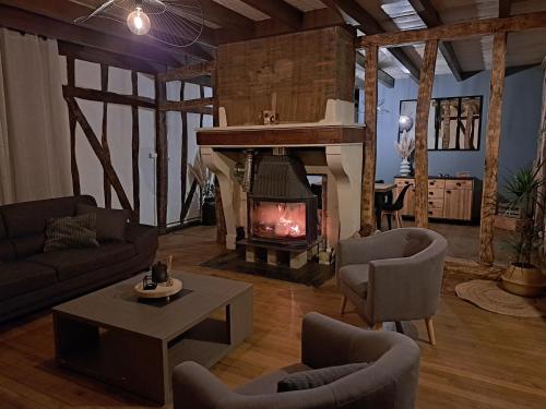 a living room with a fireplace and a couch and chairs at Bienvenue chez vous 