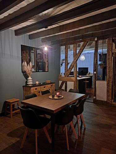 a dining room with a wooden table and chairs at Bienvenue chez vous 