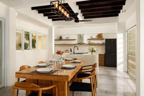 cocina y comedor con mesa de madera y sillas en Villa Swarna by Nakula, en Seminyak