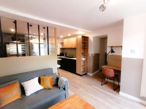 un salon avec un canapé bleu et une cuisine dans l'établissement L'Élégant avec garage, proche Axone, Stellantis, à Audincourt