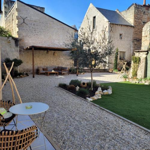 a garden with a patio with a table and chairs at H&ocirc;tel Rive Sud in Chinon