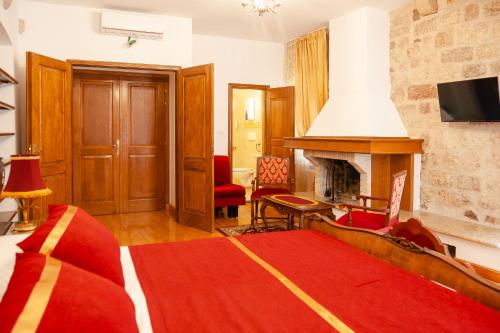 a bedroom with a fireplace and a red rug at Casa Antica Druško in Kotor