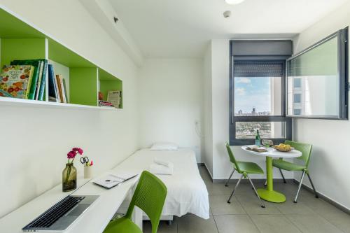 a room with a bed and a table with a laptop at דירות גני תערוכה - TLV university apartments near Expo by Sea N' Rent in Tel Aviv